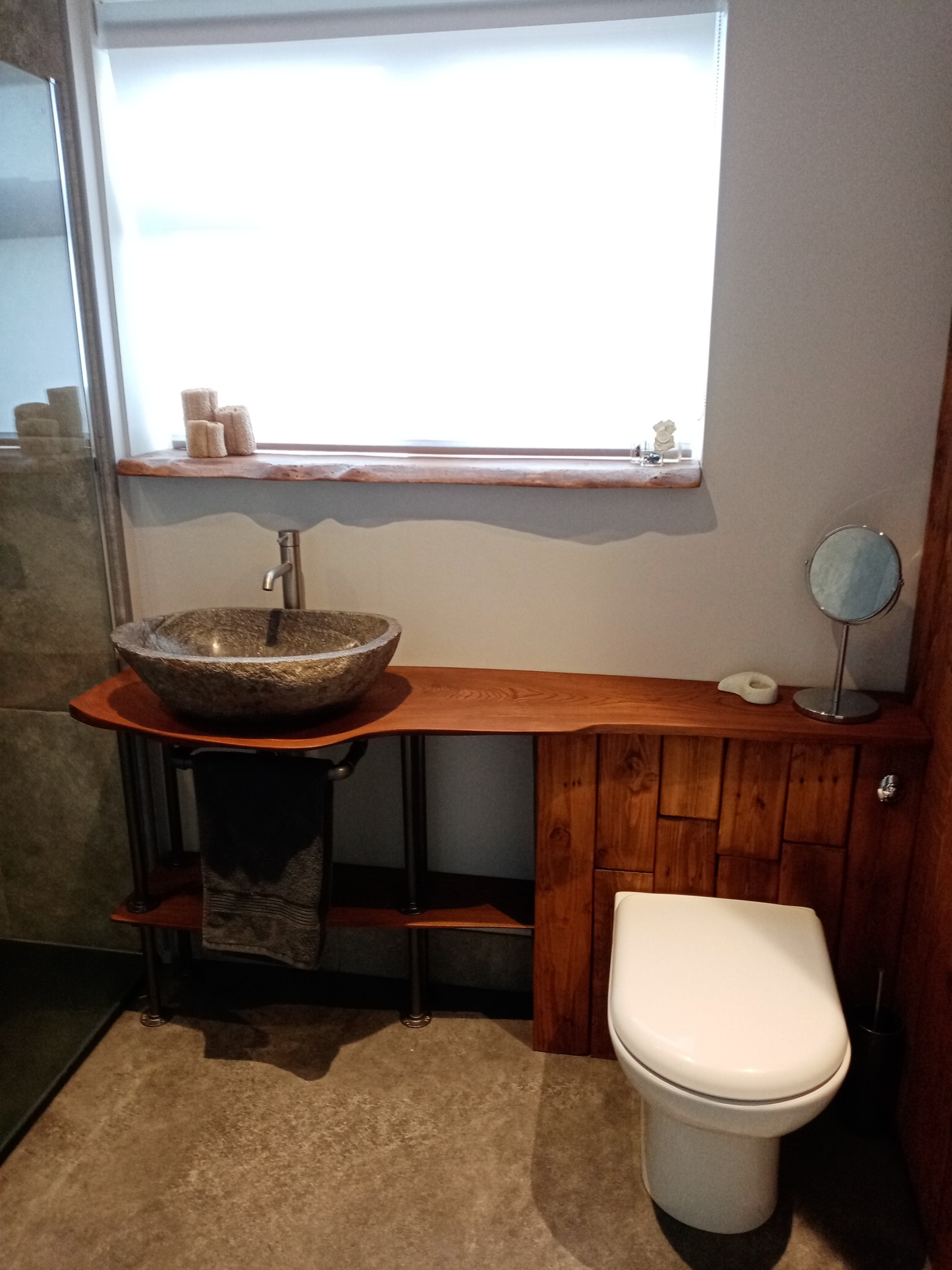 Earthy and natural bathroom designed by Paint and Plan, with elm wood slab countertop and boulderstone sink